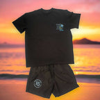 Men's R3 Fashion Members club black swimming trunks with pockets and blue logo, paired with matching black T-shirt against sunset beach background