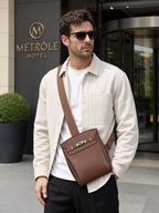 Man wearing the Sinclair brown sling bag in front of a hotel