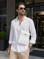 Man wearing the Sinclair white sling bag in front of a hotel