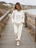 Gebreide hoodie wit - model loopt op strandboulevard