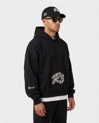 Model wearing the black Hustler Mid R3 hoodie by R3CEIVED, three-quarter view