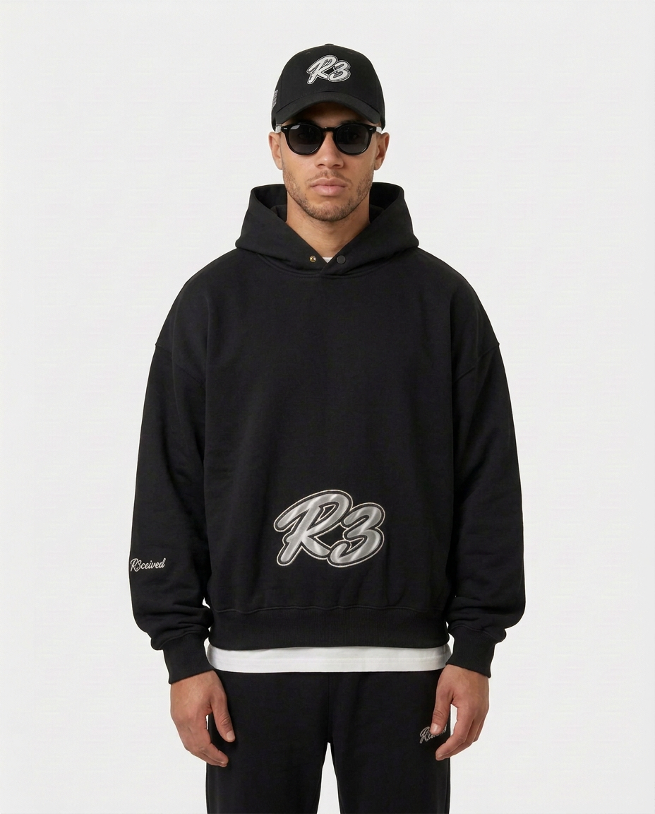 Model wearing the black Hustler Mid R3 hoodie by R3CEIVED, front view