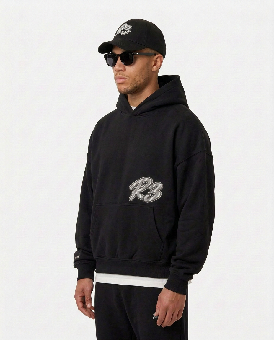Model wearing the black Hustlers Classic Hoodie by R3CEIVED, angled view