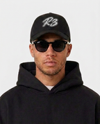 Model wearing the black Hustlers Baseball Cap by R3CEIVED, front view