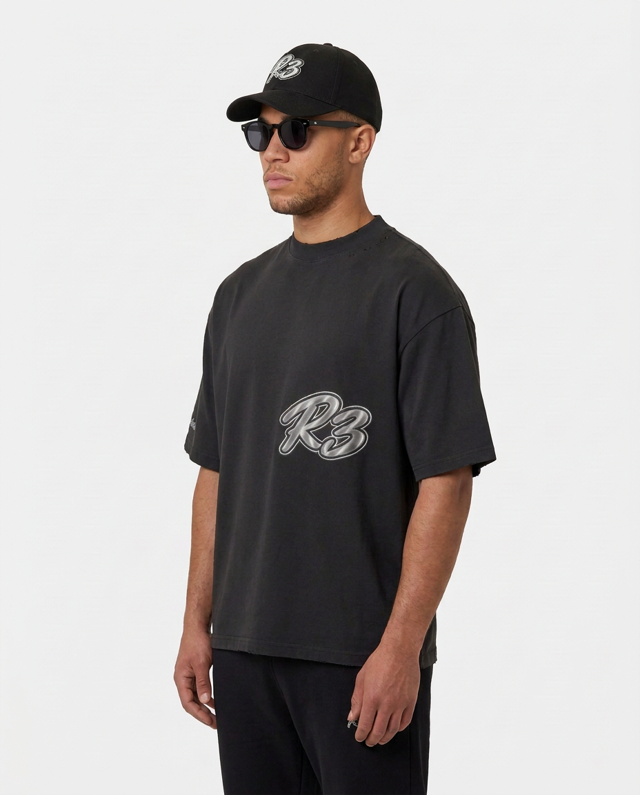 Model wearing the black Hustlers Washed Drop-Shoulder T-Shirt by R3CEIVED, angled view