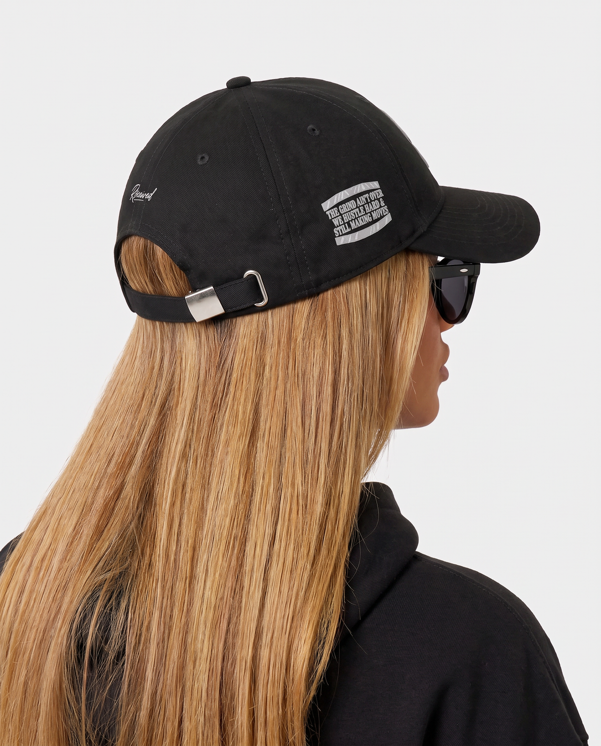 Hustlers Cotton Baseball Cap black - female model angled back view with buckle strap