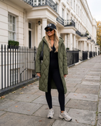 Aspen Ribbed Jumpsuit in black styled with the Chamonix Quilted Coat in Army Green on a London street